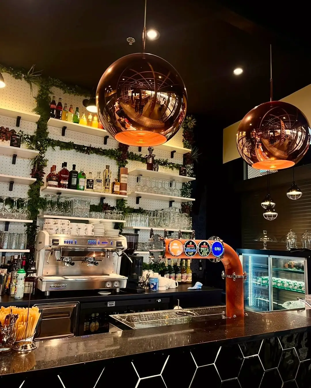Le bar et ses suspensions en boules de cuivre.