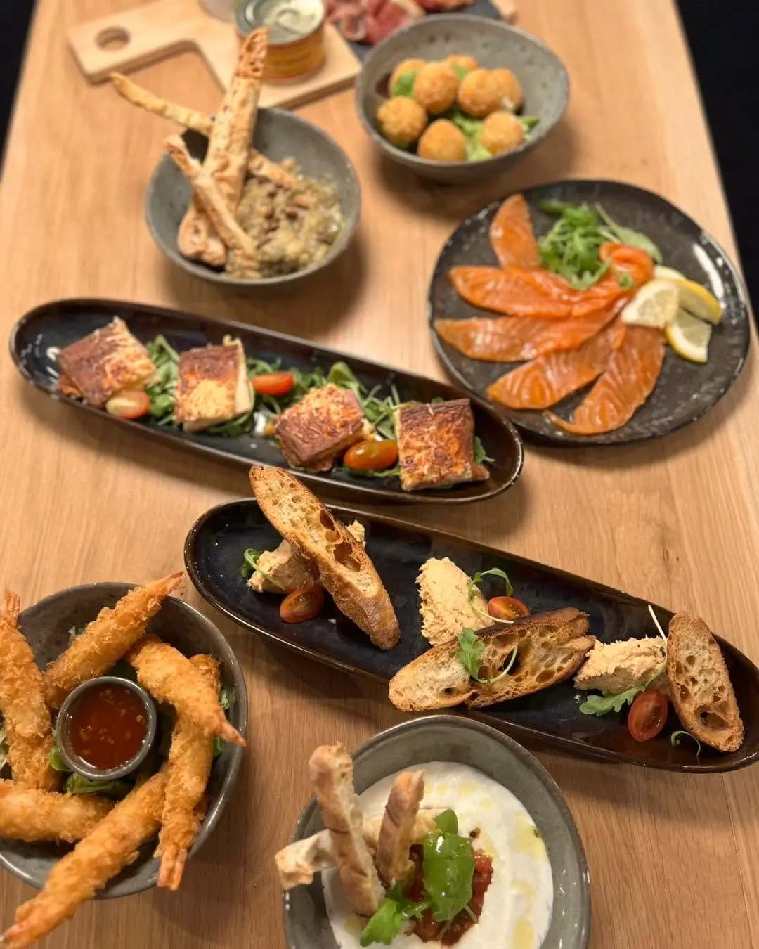 Des tapas réunies sur une table en bois.